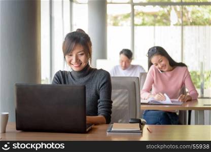 young beautiful asian smiling businesswoman working in startup office, happy work concept