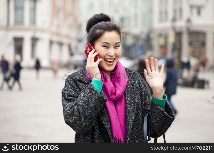 Young beautiful asian woman calling by phone on the spring street