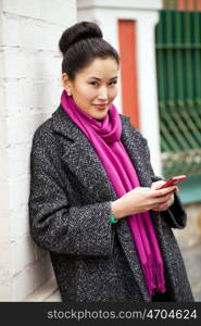 Young beautiful asian woman calling by phone on the spring street