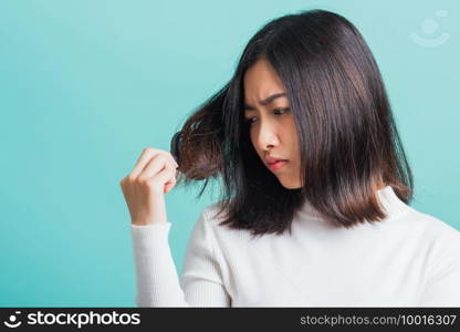 Young beautiful Asian woman upset with a comb and problem hair, Portrait female shocked suffering from hair loss problem, studio shot isolated on a blue background, medicine health concept