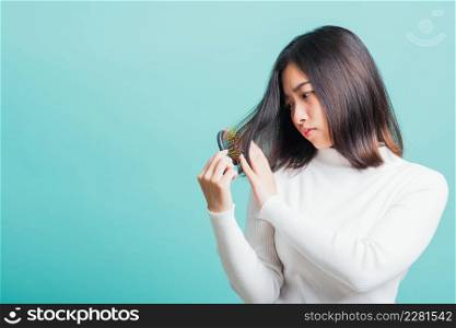 Young beautiful Asian woman upset with a comb and problem hair, Portrait female shocked suffering from hair loss problem, studio shot isolated on a blue background, medicine health concept