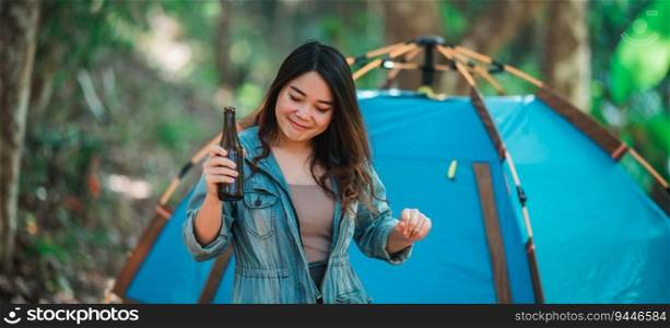 Young beautiful Asian women and friends travelers relaxing at front of c&ing tent, They enjoy to talking and drinking beer with fun and happy together