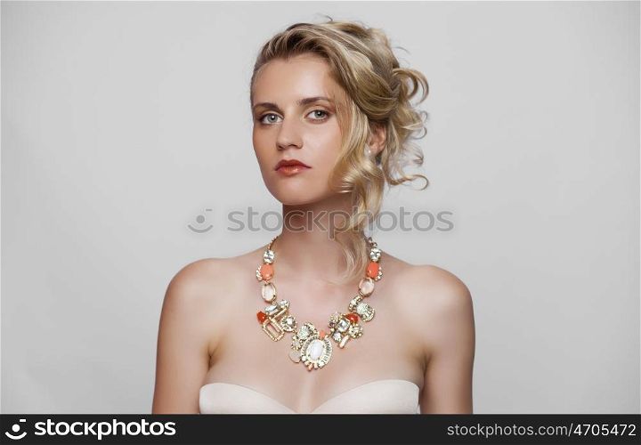 Young beautiful blond girl with a wedding hairstyle. Portrait of the bride on a white background isolated