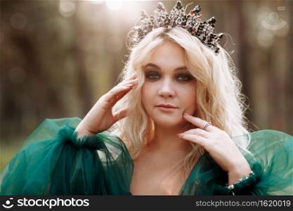 young beautiful blonde hair woman queen. Princess walks. autumn green forest mystic. Vintage medieval shiny crown. Long evening green dress. magic fantasy.. young beautiful blonde hair woman queen. Princess walks. autumn green forest mystic. Vintage medieval shiny crown. Long evening green dress. magic fantasy