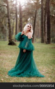 young beautiful blonde hair woman queen. Princess walks. autumn green forest mystic. Vintage medieval shiny crown. Long evening green dress. magic fantasy.. young beautiful blonde hair woman queen. Princess walks. autumn green forest mystic. Vintage medieval shiny crown. Long evening green dress. magic fantasy