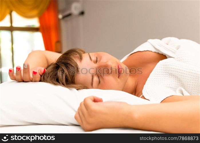 young beautiful brunette sleeping on her back in bed