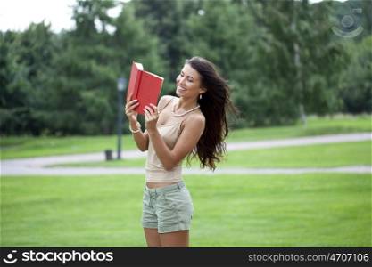 Young beautiful brunette woman and holds book