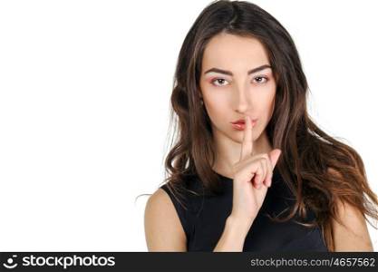 Young beautiful brunette woman has put forefinger to lips as sign of silence