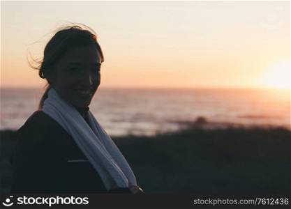 Young beautiful chinese woman exercising at the beach at sunrise/sunset