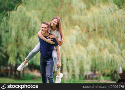Young beautiful couple having fun in the park.. Relaxed young family outdoor in the park