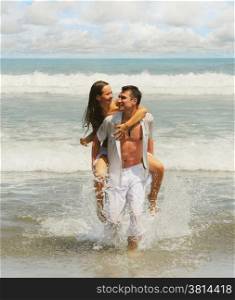 Young beautiful couple in love on a sunny beach