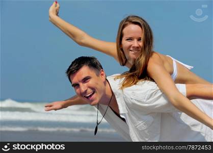 Young beautiful couple in love on a sunny beach