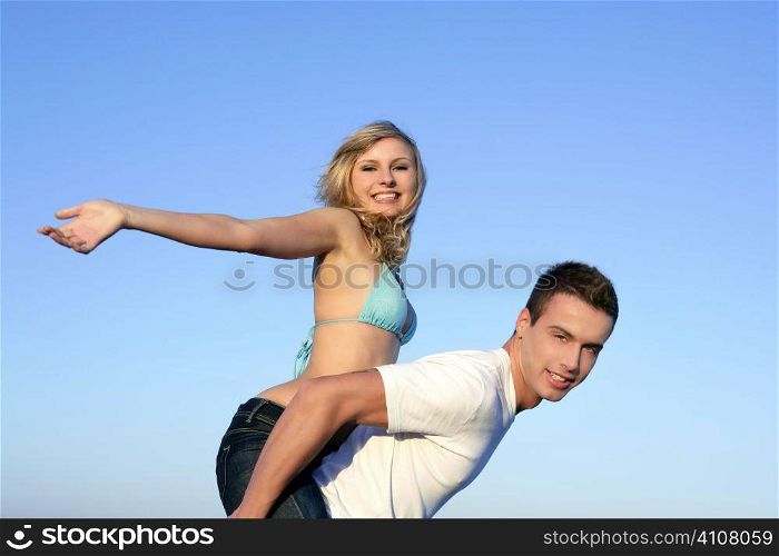 Young beautiful couple playing on the blue beach