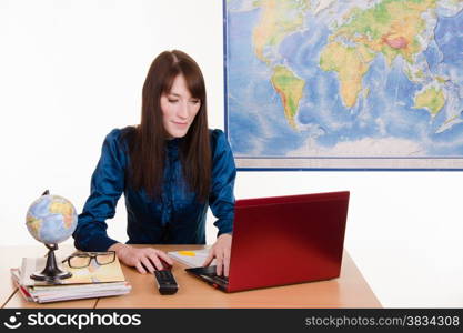 Young beautiful employee in the office of the travel agency