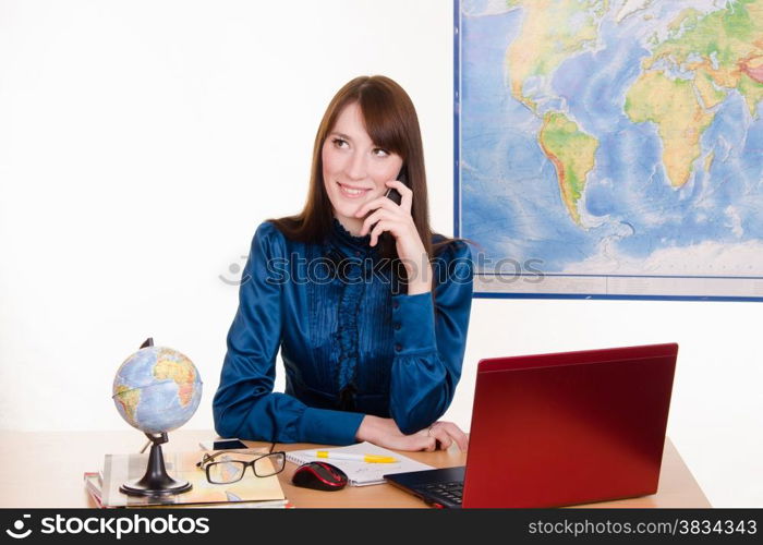 Young beautiful employee in the office of the travel agency