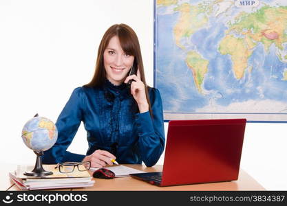 Young beautiful employee in the office of the travel agency