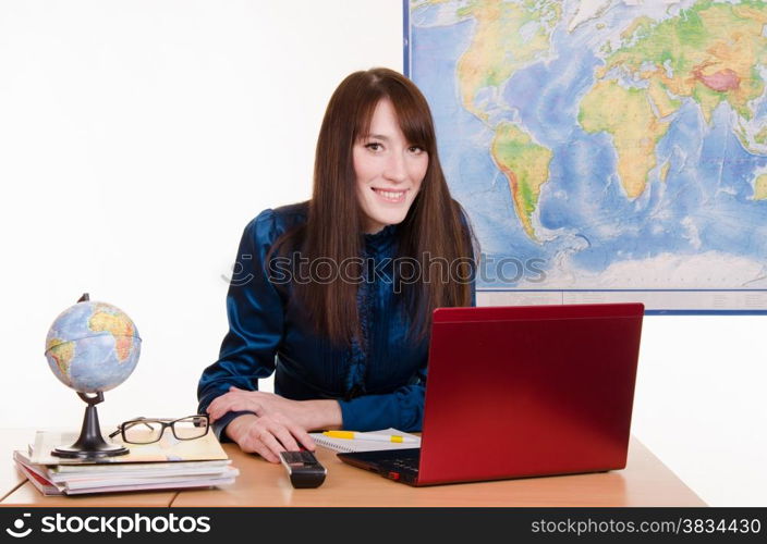 Young beautiful employee in the office of the travel agency