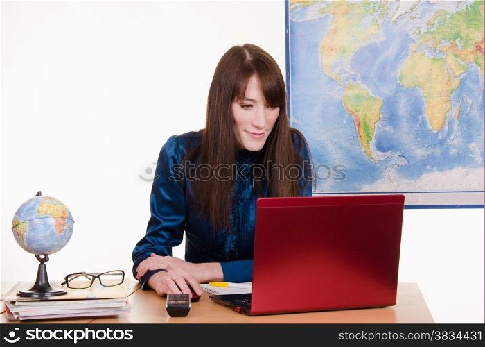 Young beautiful employee in the office of the travel agency
