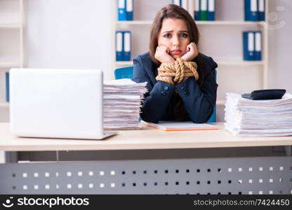 Young beautiful employee tied up with rope in the office 