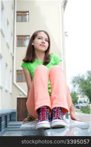 young beautiful european girl sitting on banister