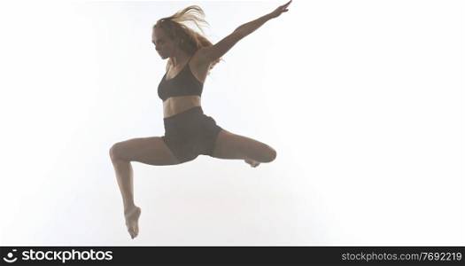 young beautiful female sporty dancer in black tights performing modern style ballet making acrobatic elements female ballet dancer in art performance in front of white background