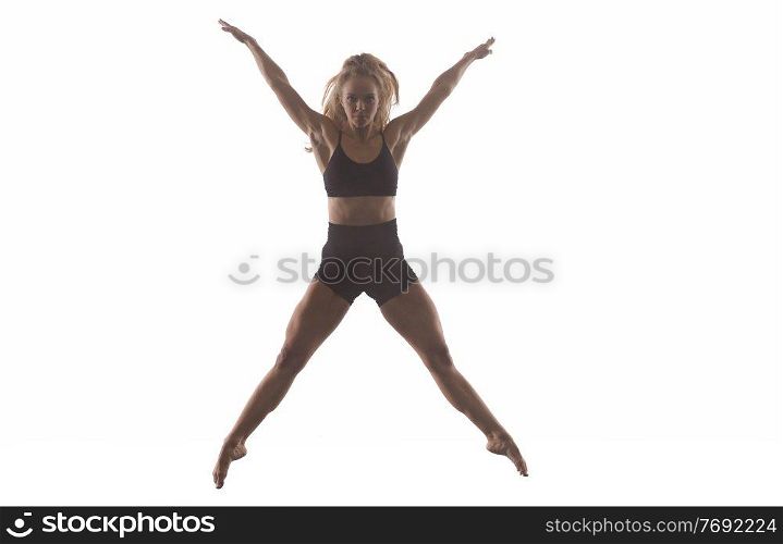young beautiful female sporty dancer in black tights performing modern style ballet making acrobatic elements   female ballet dancer in art performance in front of white background
