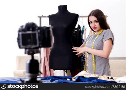 Young beautiful female tailor recording video for her blog