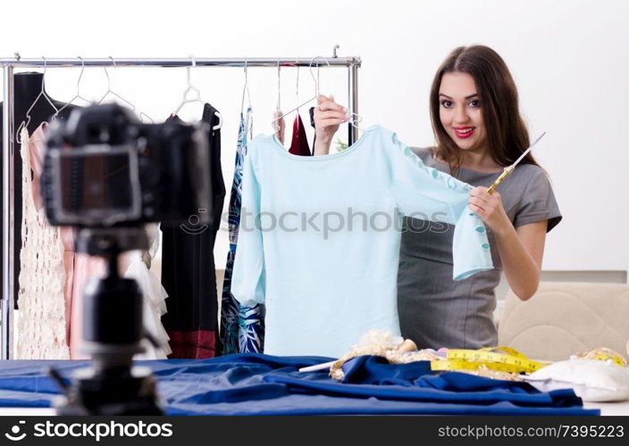 Young beautiful female tailor recording video for her blog