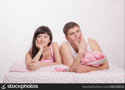 Young beautiful girl and the guy in bed resting in bed