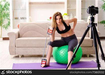 Young beautiful girl blogger doing exercises at home