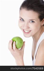 Young beautiful girl holding a green apple on a white background