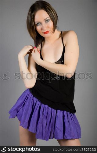 Young beautiful girl in a black blouse and blue skirt