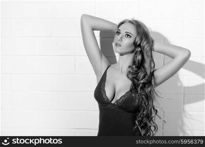 Young beautiful girl in brown underwear on white wall (monochrome version)