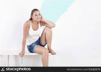 Young beautiful girl on a background of painted wall