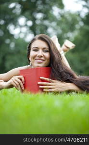 Young beautiful girl reading a book outdoor