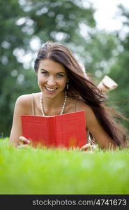 Young beautiful girl reading a book outdoor