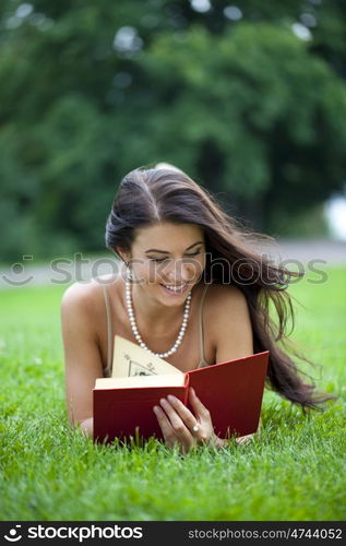 Young beautiful girl reading a book outdoor