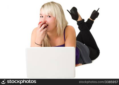 Young beautiful girl using here laptop while eating an apple. Over white background