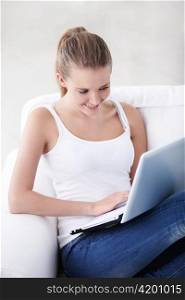 Young beautiful girl with a laptop on the couch
