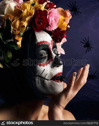 Young beautiful girl with traditional mexican death mask. Calavera Catrina. Sugar skull makeup. girl dressed in a wreath of roses on a background of white web