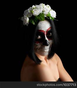Young beautiful girl with traditional mexican death mask. Calavera Catrina. Sugar skull makeup. girl dressed in a wreath of white roses