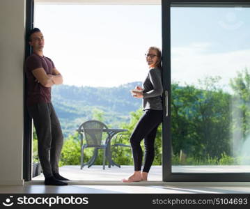 young beautiful handsome couple enjoying morning coffee and breakfast on the door of their luxury home villa