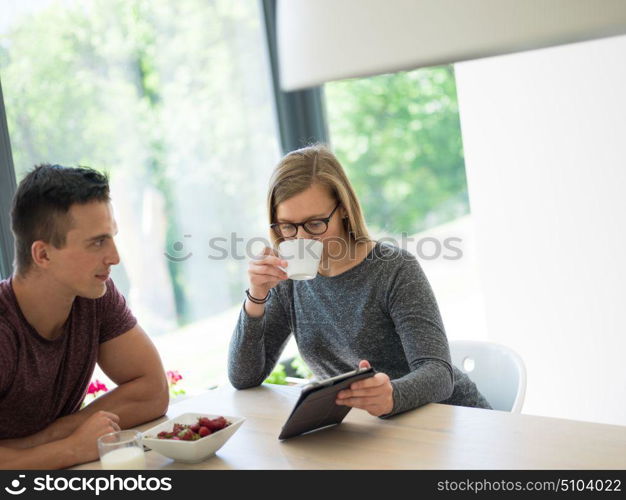 young beautiful handsome couple enjoying morning coffee and strawberries in their luxurious home villa