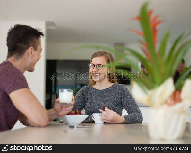 young beautiful handsome couple enjoying morning coffee and strawberries in their luxurious home villa