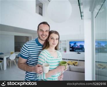 young beautiful handsome couple enjoying morning coffee at home