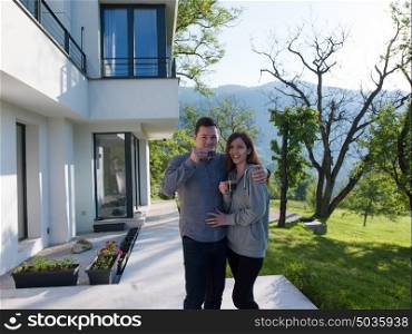 young beautiful handsome couple enjoying morning coffee in front of their luxury home villa