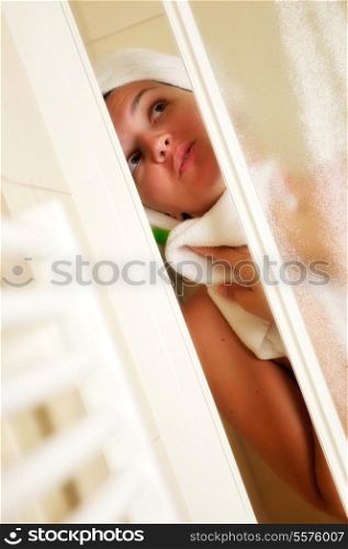 Young beautiful happy smiling tanned brunett woman at shower in bathroom