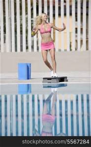 young beautiful healthy woman exercise fitness and stepping at swimming pool