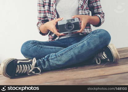 Young beautiful hipster woman with an old retro camera.