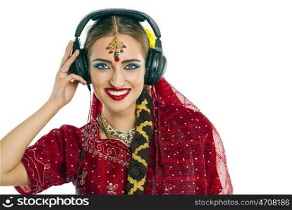 Young beautiful Indian woman listening to music on headphones
